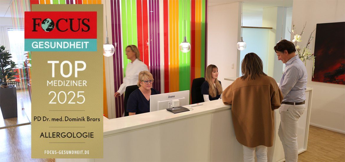 Eingangsbereich mit Anmeldung und Mitarbeitern; Banner mit Focus Auszeichnung Top Mediziner 2025
